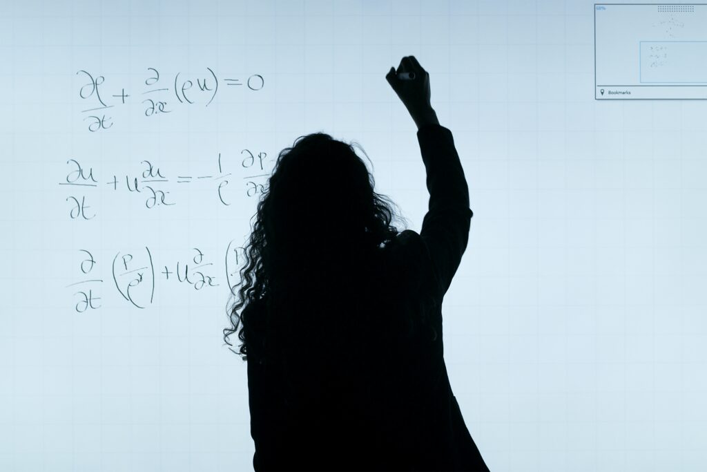 woman writing formulas on white board