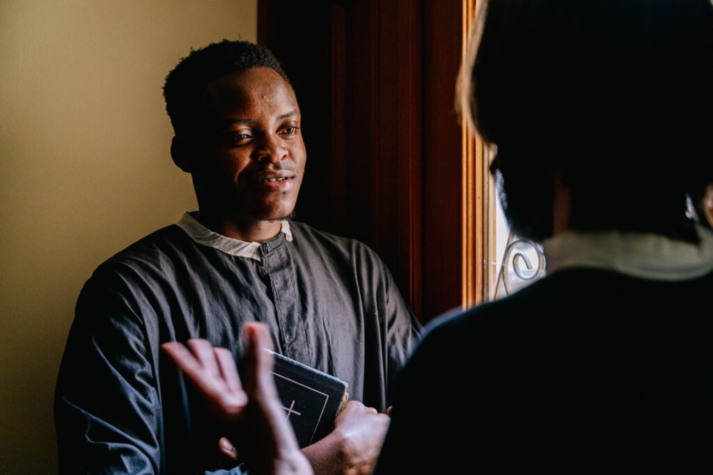 Man Wearing Cassock Hugging a Holy Bible asking questions about systematic theology