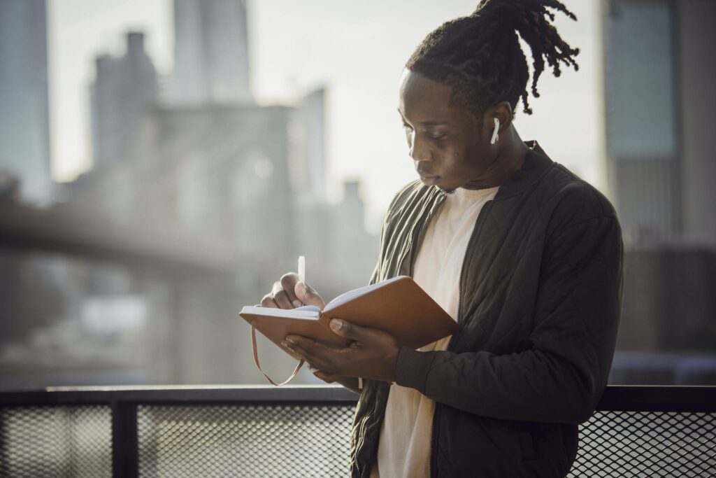 Man Writing On A Notebook