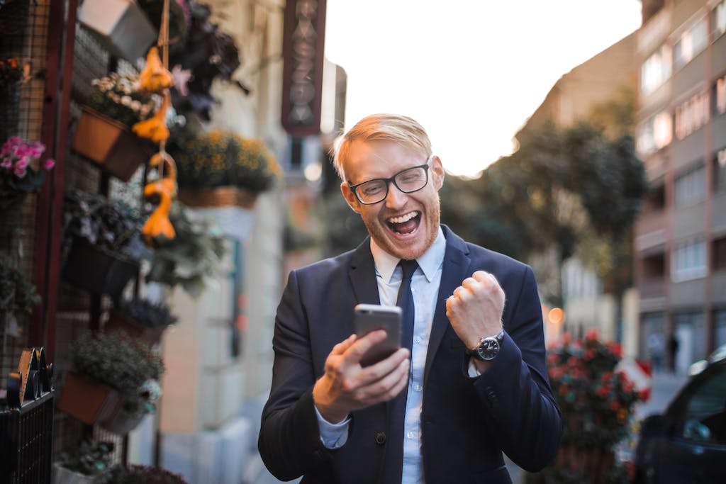 Man in Black Suit Jacket Received A Good News from his mobile marketing strategy